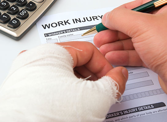 Dittmann Insurance_Personal & Commercial Insurance Southeast Kansas. Commercial workers' compensation insurance, an injured worker fills out a work injury form while holding a bandaged arm.